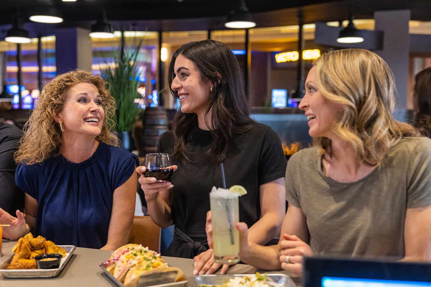 Vibrant casino dining atmosphere at Odawa Casino & Resort with friends enjoying food and drinks.