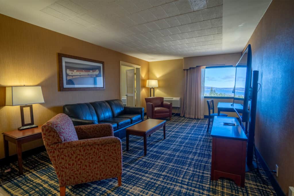 Spacious Odawa Casino & Resort hotel room with comfortable seating and scenic window view.