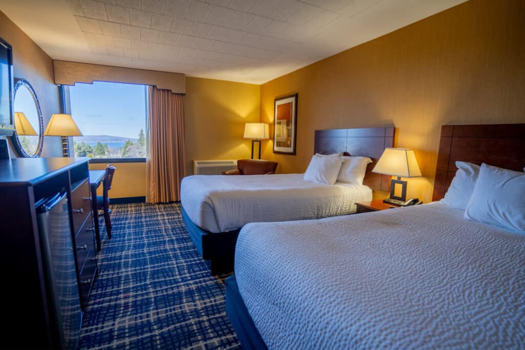 Spacious hotel room at Odawa Casino & Resort with two queen beds and scenic view.