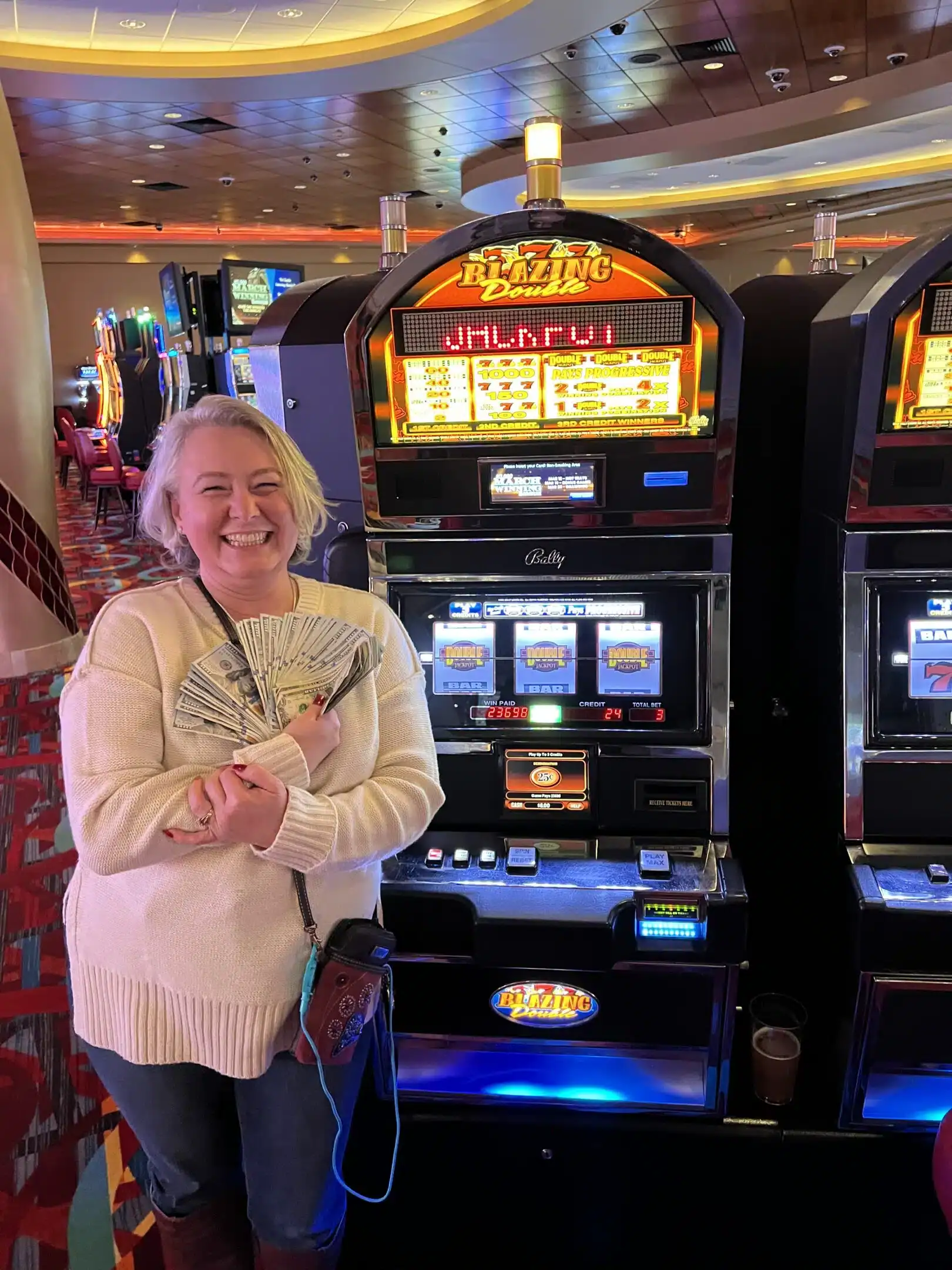 Winner with cash at Odawa Casino & Resort slot machine in Petoskey, Michigan.