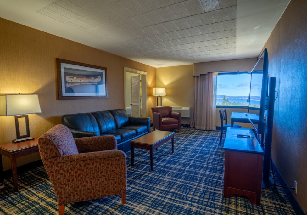 Spacious Odawa Casino & Resort hotel room with comfortable seating and scenic window view.