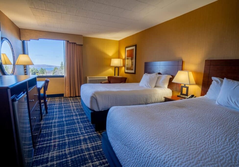 Spacious hotel room at Odawa Casino & Resort with two queen beds and scenic view.