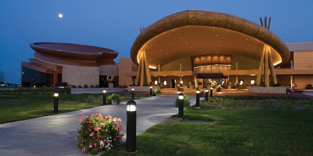 Modern Odawa Casino & Resort building at dusk with landscaped grounds and lighting, offering gaming and entertainment.