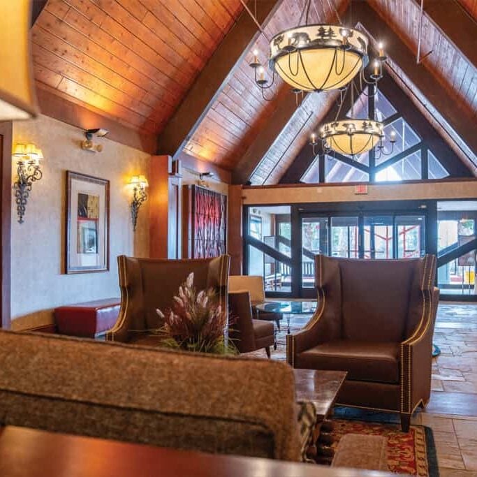 Elegant lodge lobby at Odawa Casino & Resort with wooden vaulted ceilings and contemporary lighting fixtures.