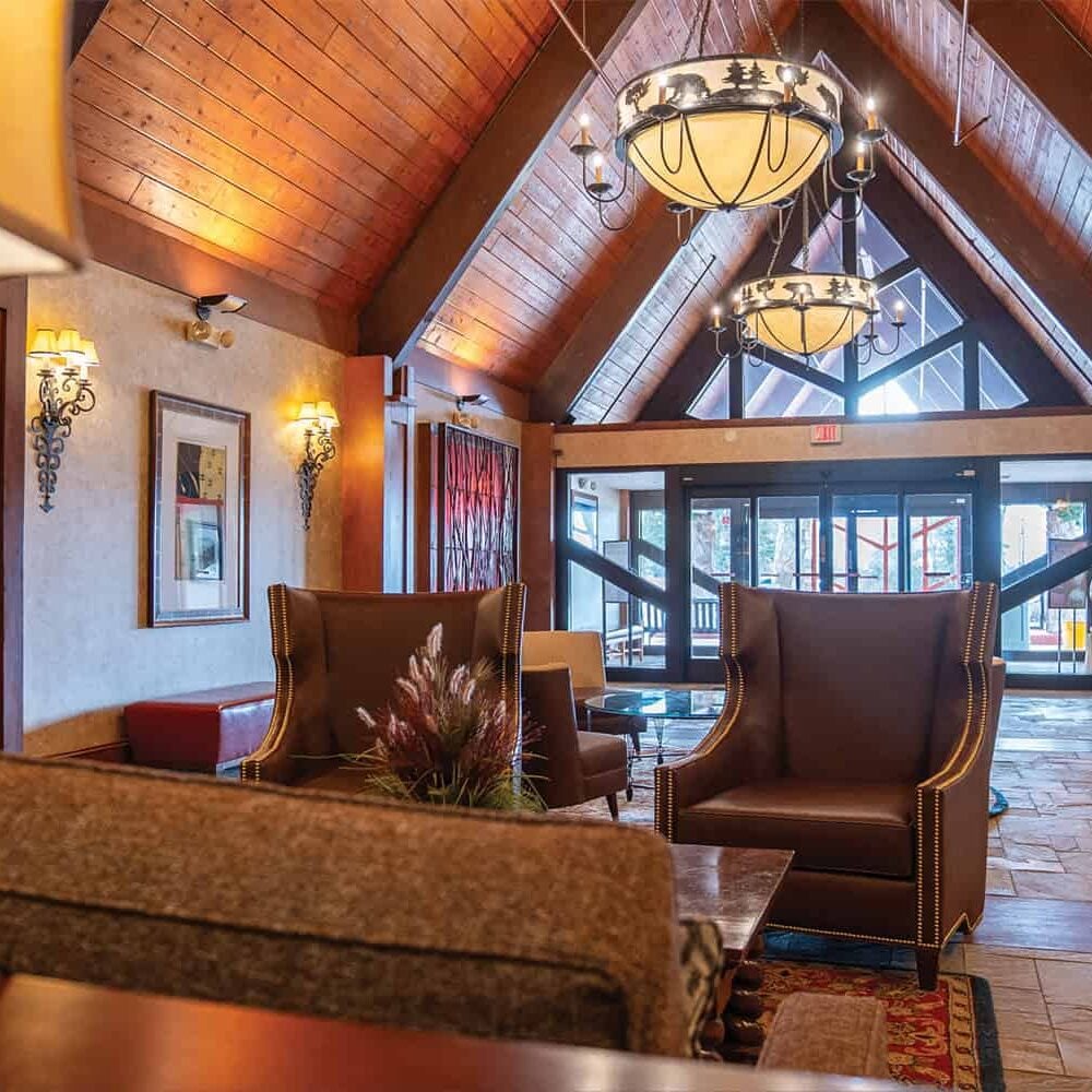 Elegant lodge lobby at Odawa Casino & Resort with wooden vaulted ceilings and contemporary lighting fixtures.