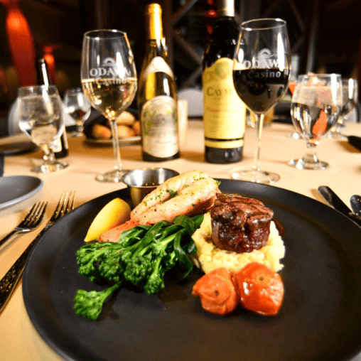 Gourmet steak dinner with vegetables and wine at Odawa Casino & Resort.