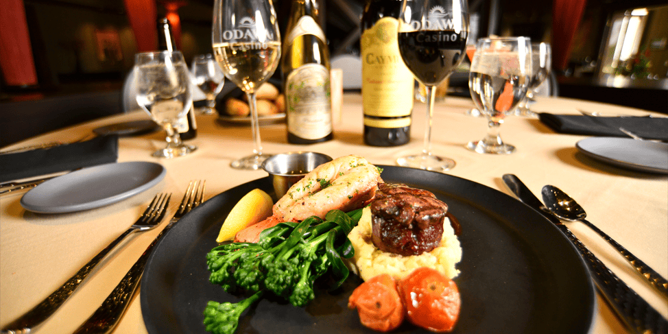 Gourmet steak dinner with vegetables and wine at Odawa Casino & Resort.