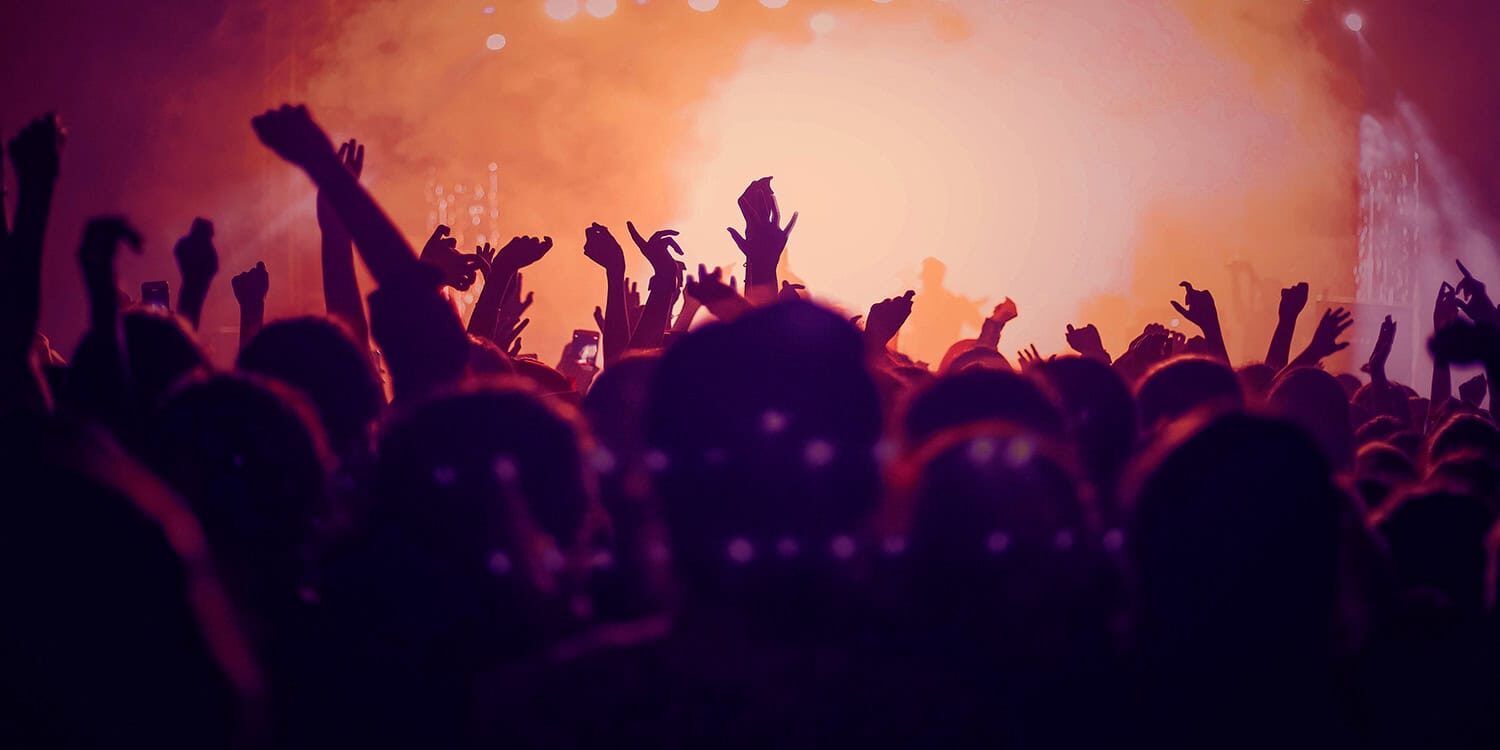 Vibrant concert crowd celebrating with hands in the air at Odawa Casino & Resort event.