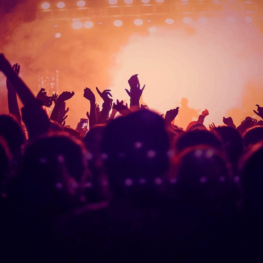 Vibrant concert crowd celebrating with hands in the air at Odawa Casino & Resort event.