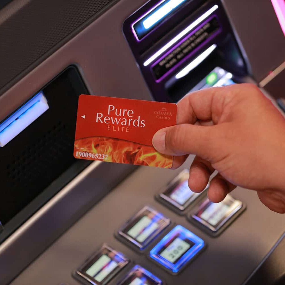 Odawa Casino & Resort loyalty card being inserted into slot machine in Michigan.
