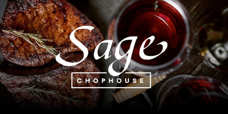 Delicious grilled steak with herbs and glasses of red wine at Sage Chophouse, Odawa Casino & Resort.