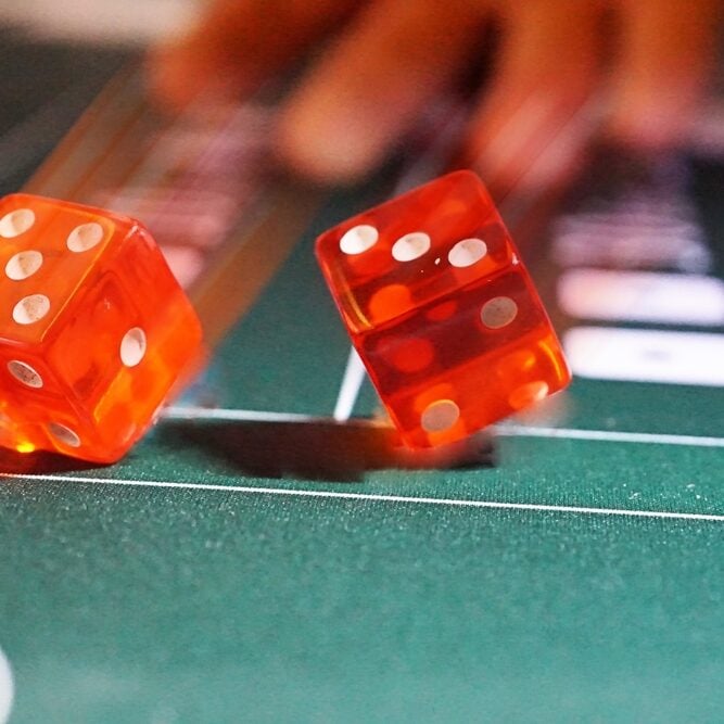 Bright red dice on a casino craps table at Odawa Casino & Resort.