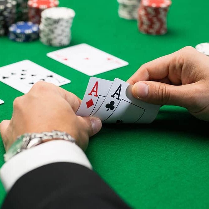 Ace of diamonds and clubs playing cards with poker chips on a green blackjack table at Odawa Casino & Resort.