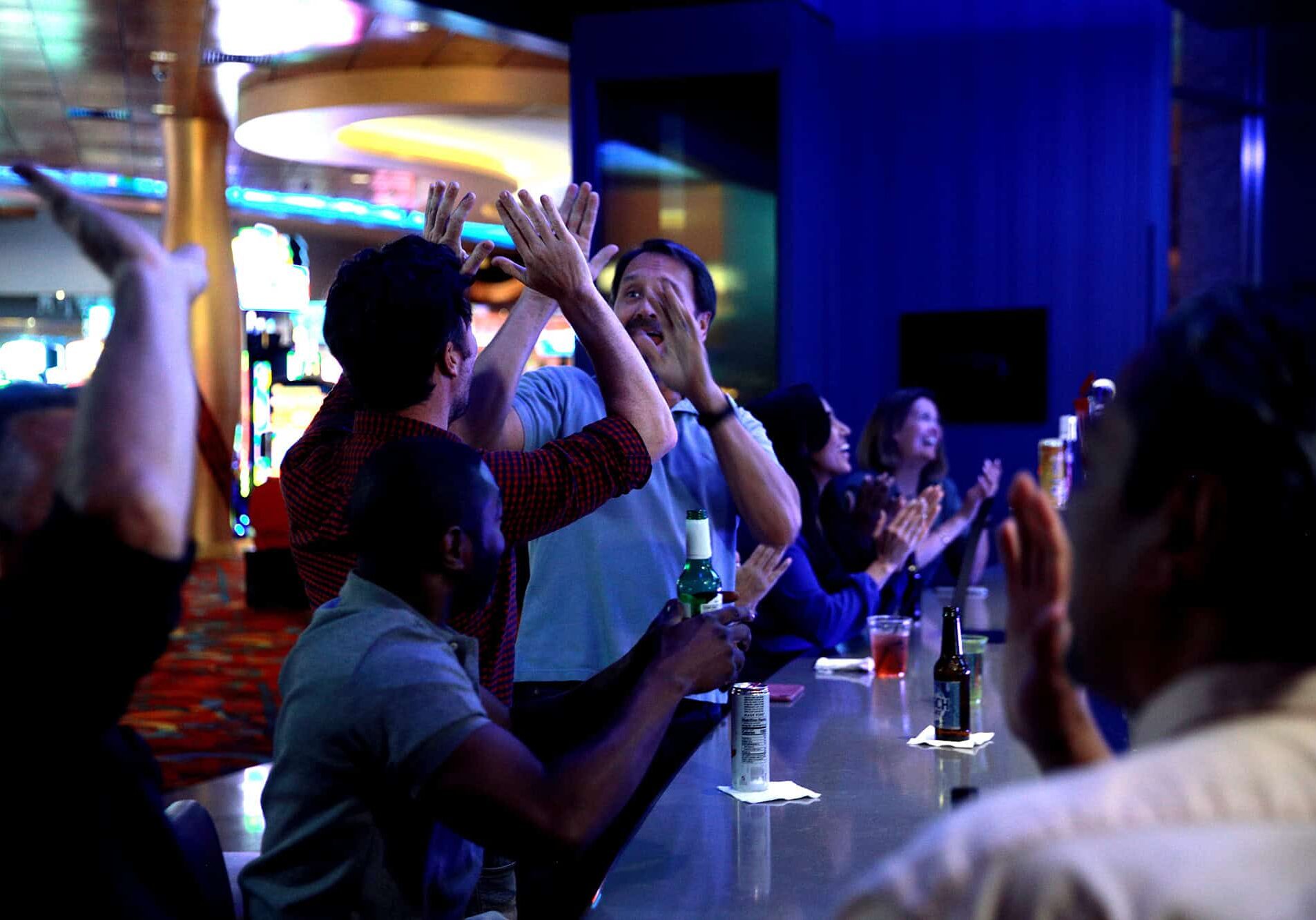 Exciting group of people celebrating at Odawa Casino & Resort bar, enjoying drinks and lively atmosphere.