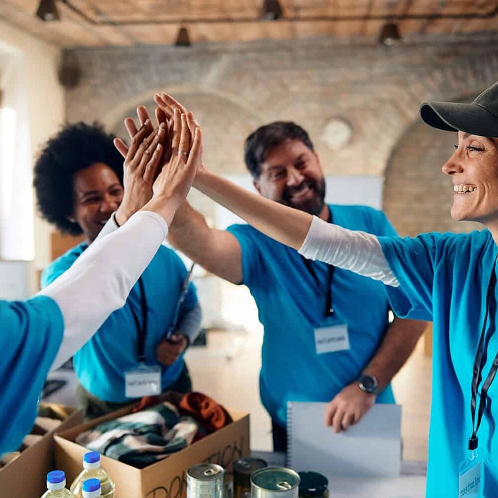 Friendly volunteers giving high five at Odawa Casino & Resort charity event.